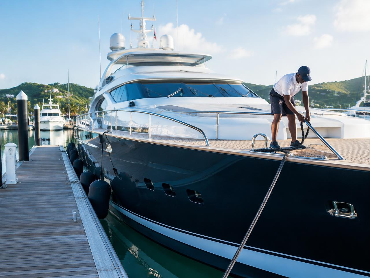 Crew member handling dock lines on a moored yacht